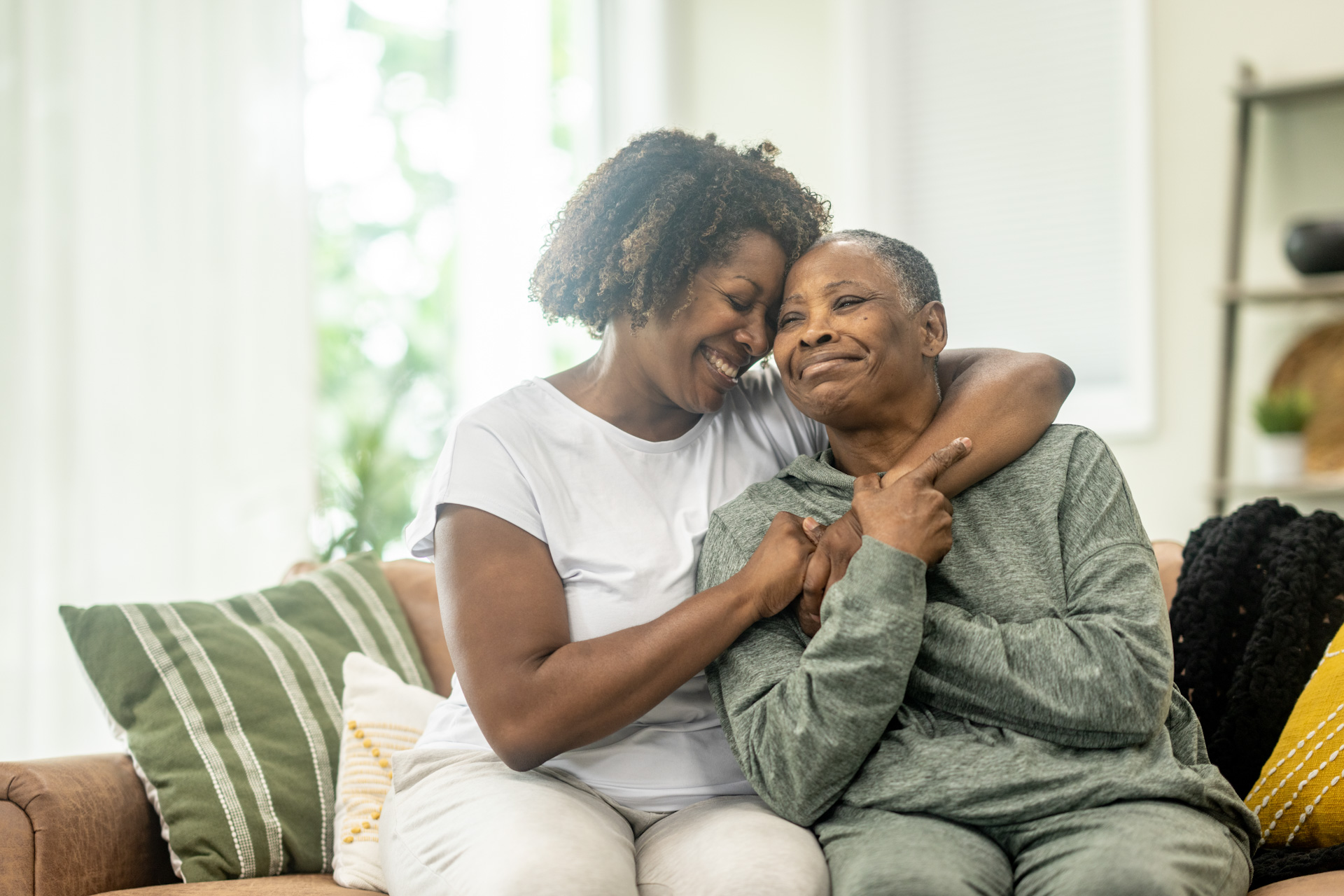 Women embracing on couch